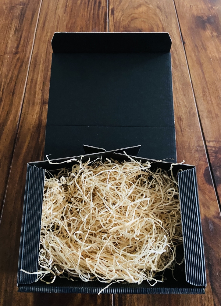 Kleiner Geschenkkarton in schwarz mit Holzwolle